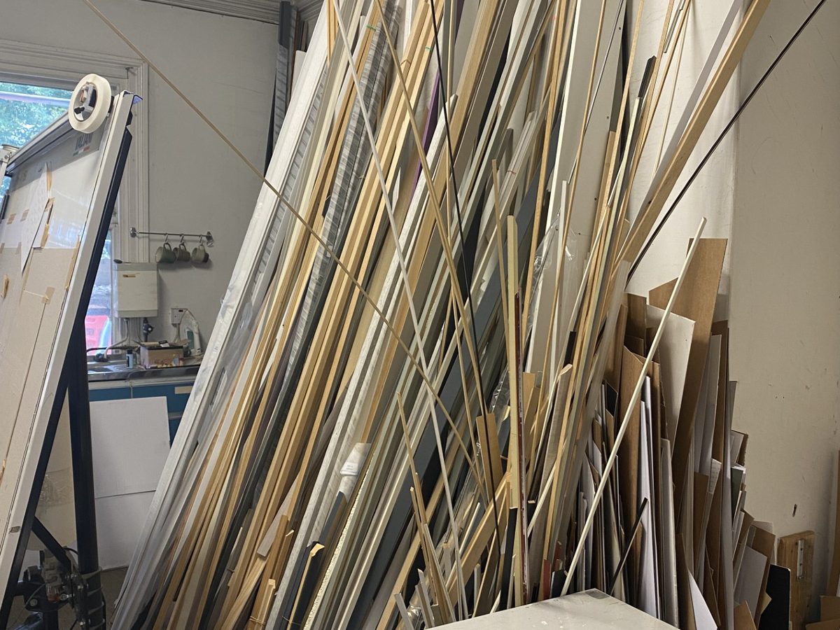 Lengths of raw moulding leaning by the bench and guillotine in the Weaverbird workshop