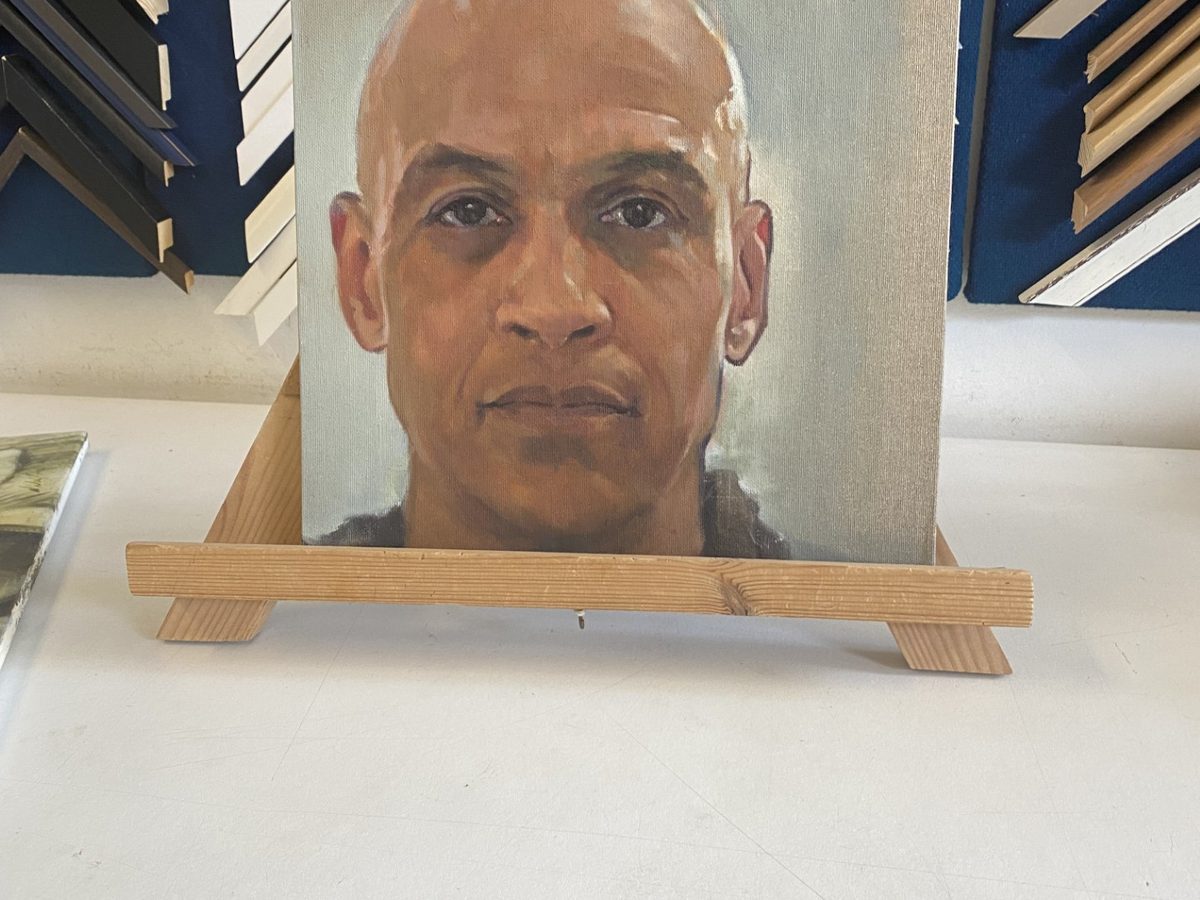 An oil portrait by Nik Walford, framed and shown in the gallery.